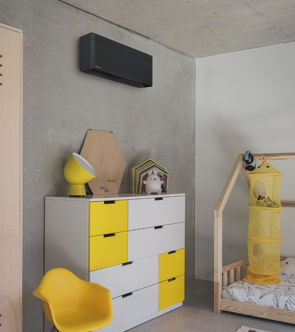 Kinderzimmer mit gelben Details und Daikin Klimagerät in schwarz
